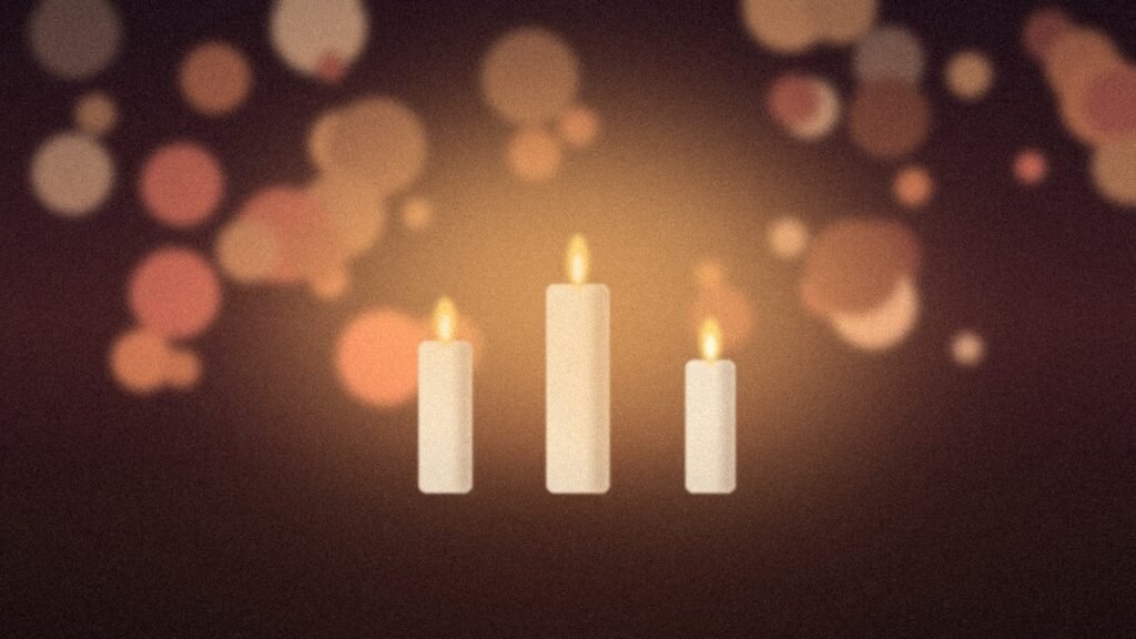 Three glowing candles with warm golden bokeh, a soft scene for birthday blessings
